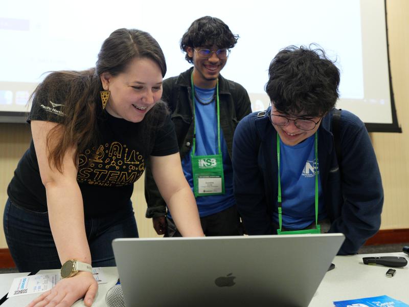 Bishoff teaching two students at the National Science Bowl