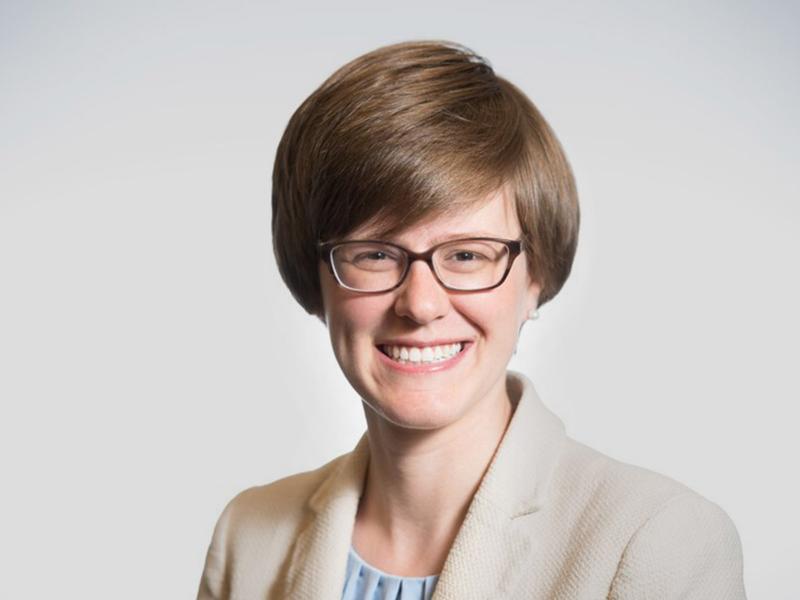 White woman with glasses and short brown hair smiling