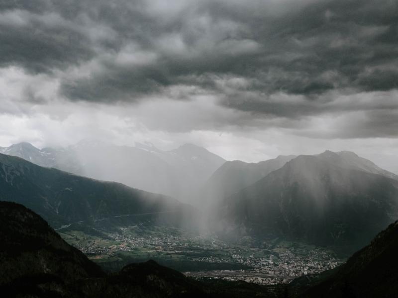 Photograph of a cloudy sky over a mountain-surrounded town