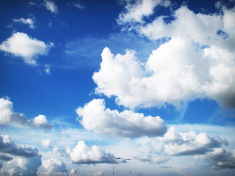 Photograph of puffy clouds floating in the sky.
