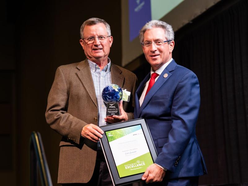 Two men holding an award plaque