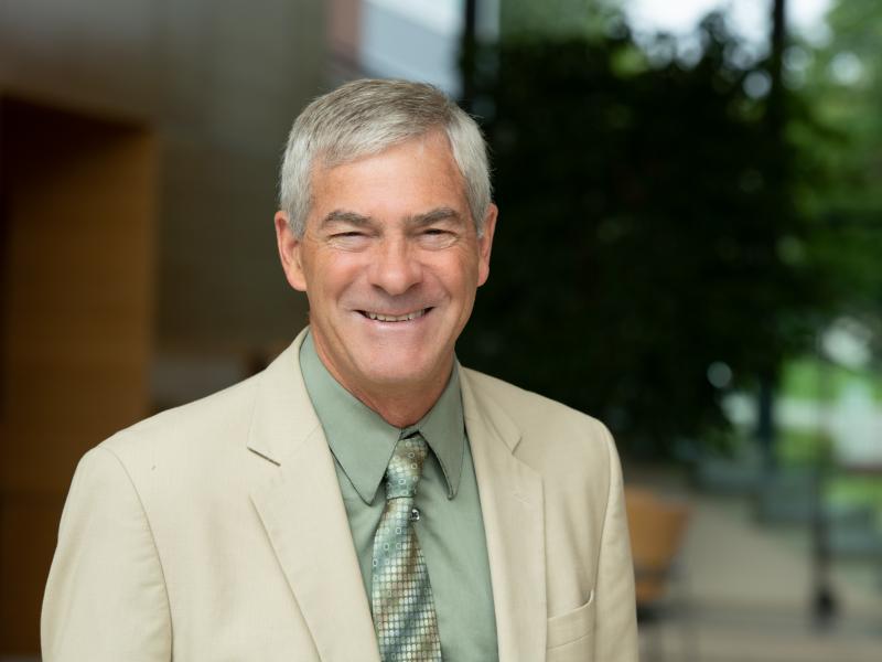 Photograph of a smiling man wearing business attire