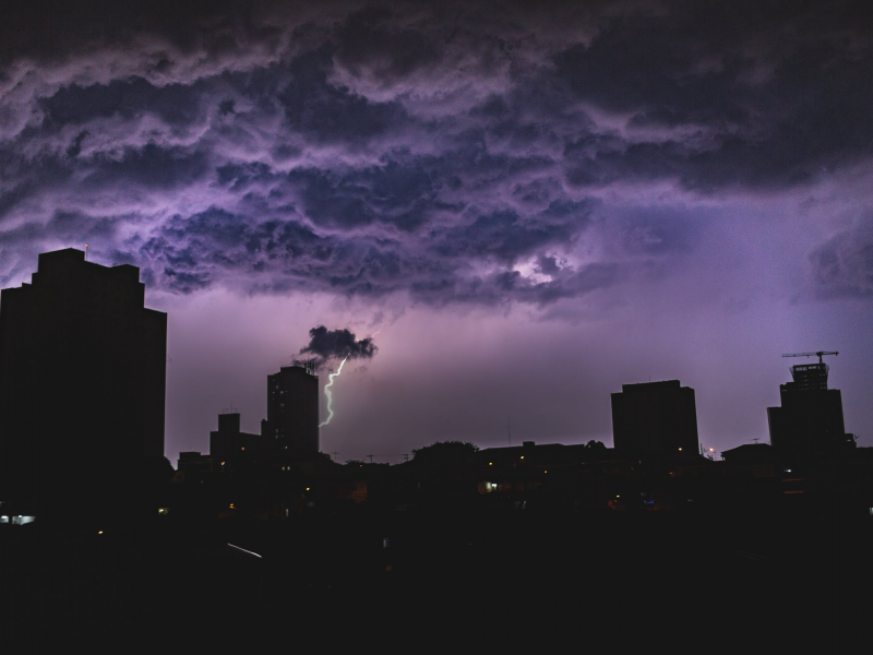 Dark image of a thunderstorm over a cityscape