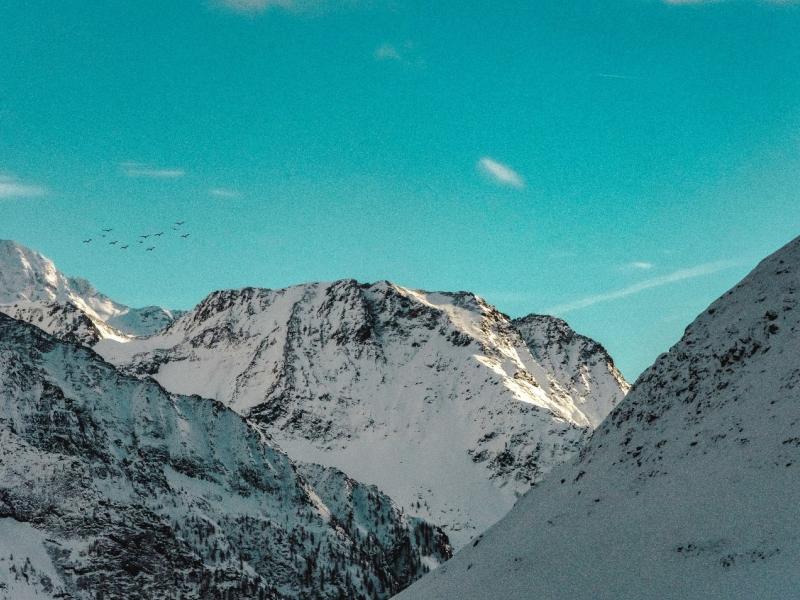 Close up of snowy mountain peaks against a bright blue, clear sky