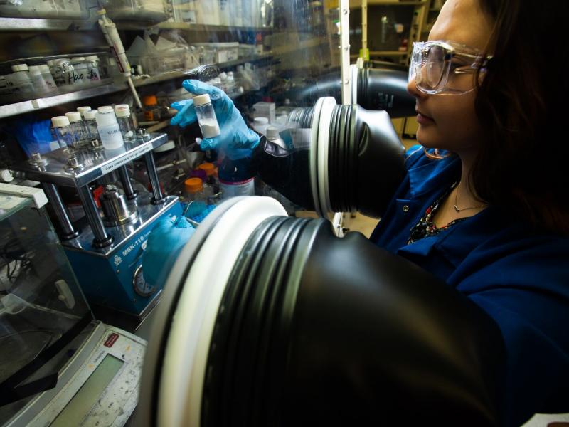 Woman working at lab glove box.