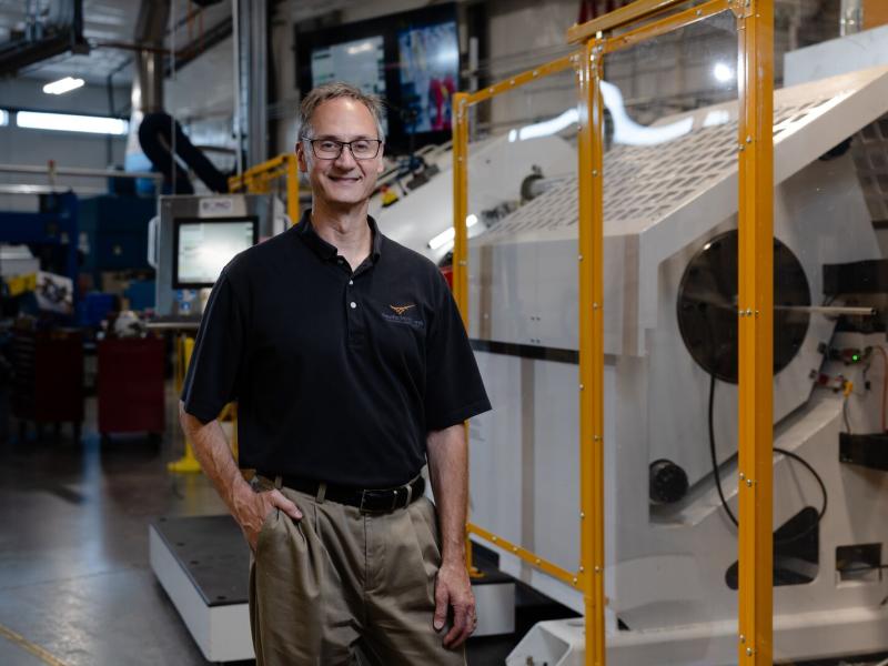 A man standing next to a machining device
