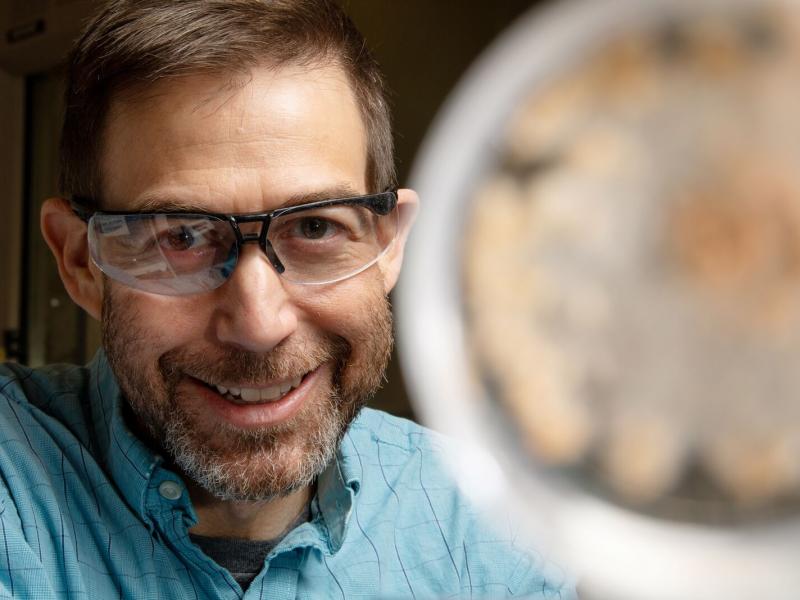 photo of PNNL researcher Scott Baker who is wearing glasses and is near a fungi sample.
