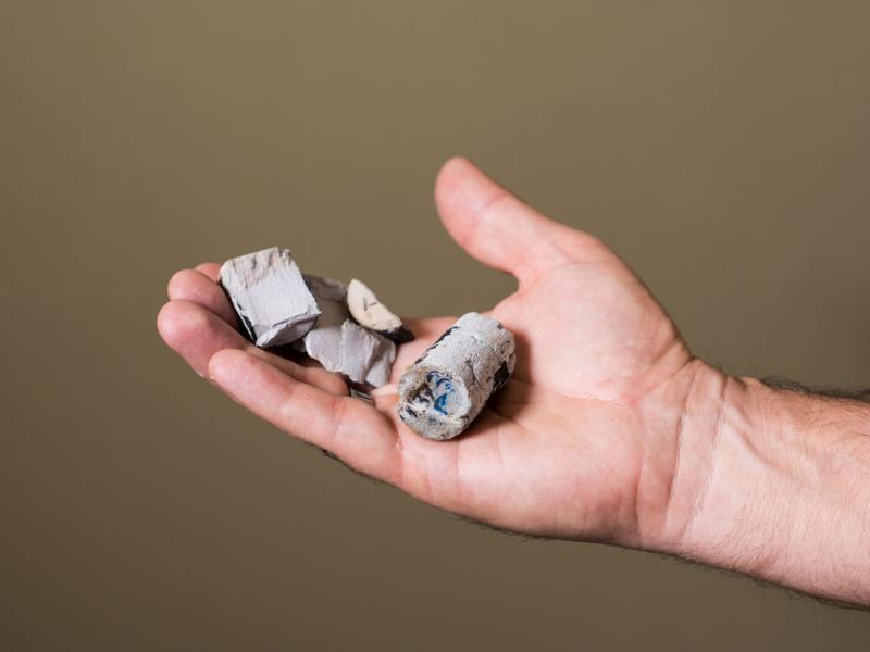 A hand holding blocks of cement