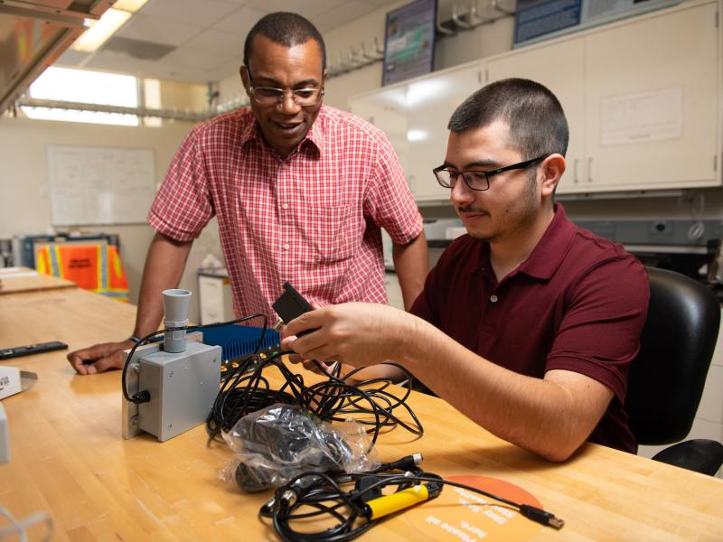 Isidro Garcia and his STEM mentor, PNNL physicist Cheslan Simpson are preparing to test a commercial occupancy sensor.