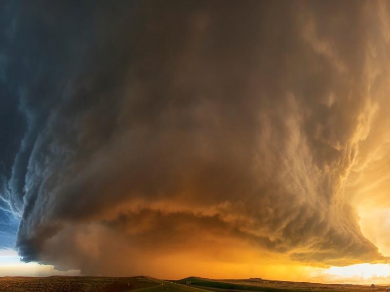 Dramatic photo of dark cloud wall with sunlight behind