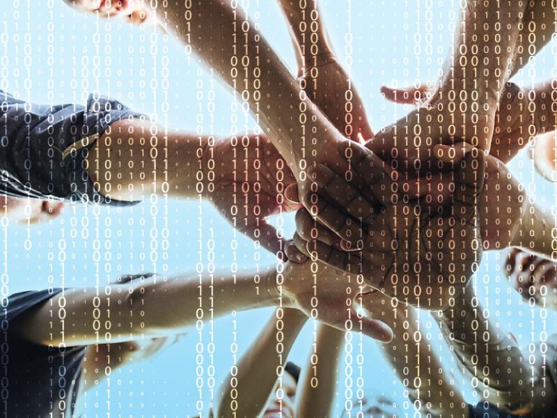 Diverse group of people, hands together with computer code in background