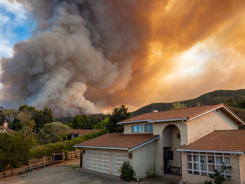 Wildfire, ignited by dry lightning, rages just behind a California home. (© David A. Litman | Shutterstock.com)