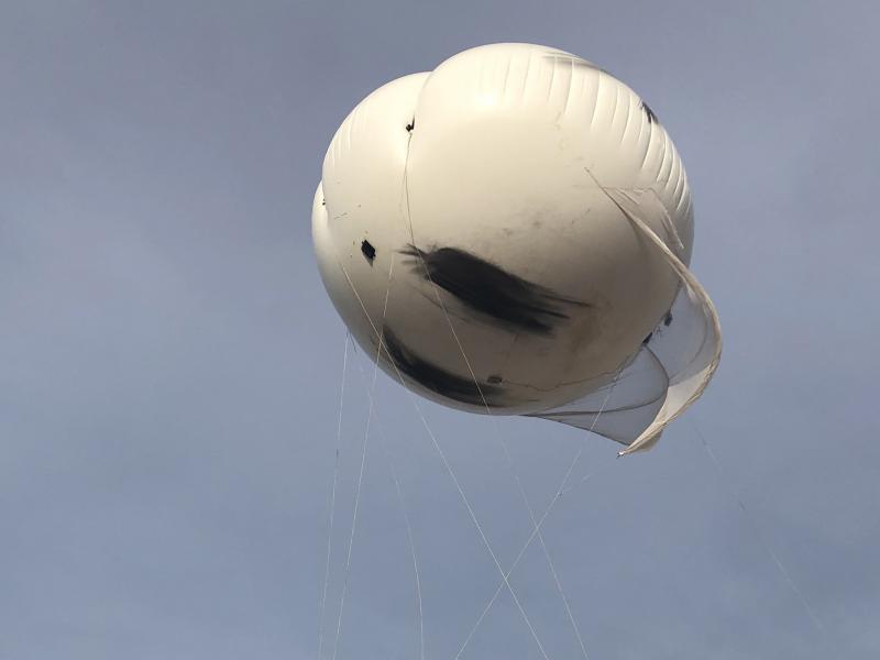 White weather balloon in a cloudy gray sky