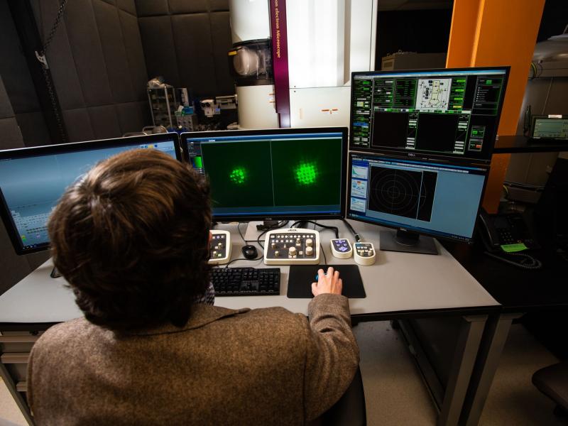 Research Steven Spurgeon uses multiple hand controls and monitors to conduct research in a large microscope in the basement of a research building