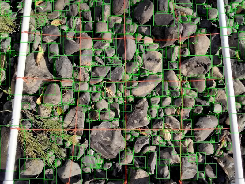Top-down view of riverbed sediment samples with green digital squares overlaying them.