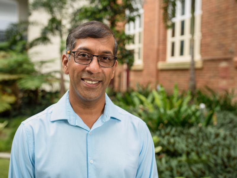 man with glasses smiles at the camera