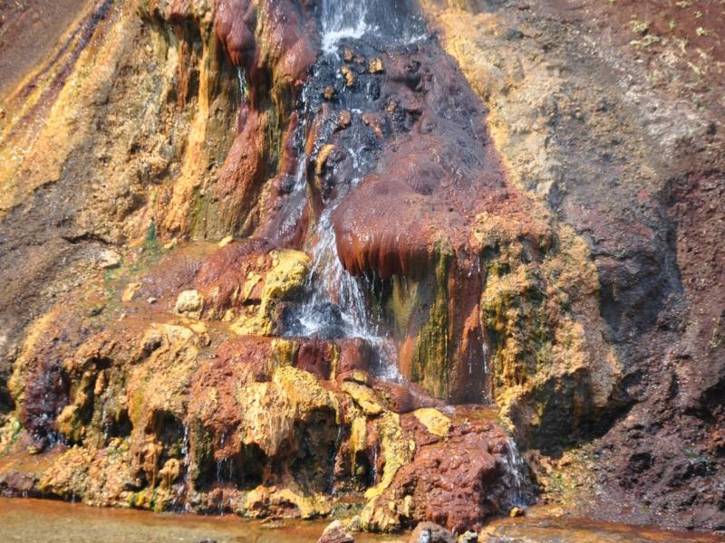 Photograph of naturally occurring ferrihydrite at the edge of a river