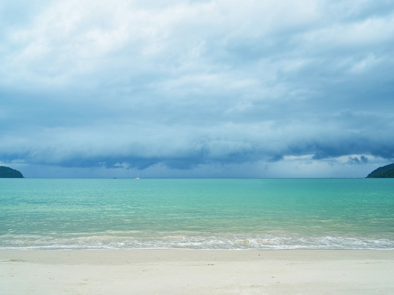 Beach with bright water and clouds above