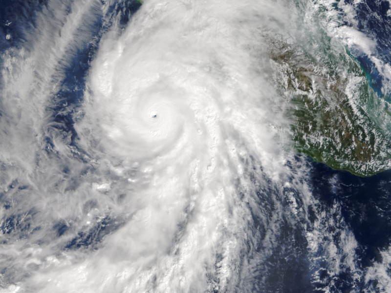 Image of a white tropical cyclone over a portion of Mexico and the Pacific Ocean.