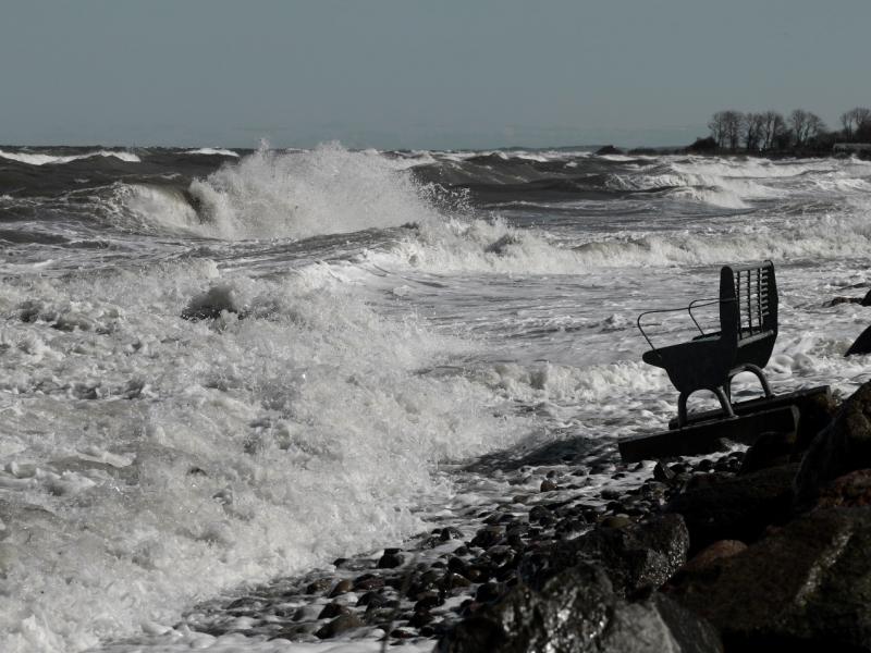 Photograph of waves reaching a seaside bench during an extreme sea level event