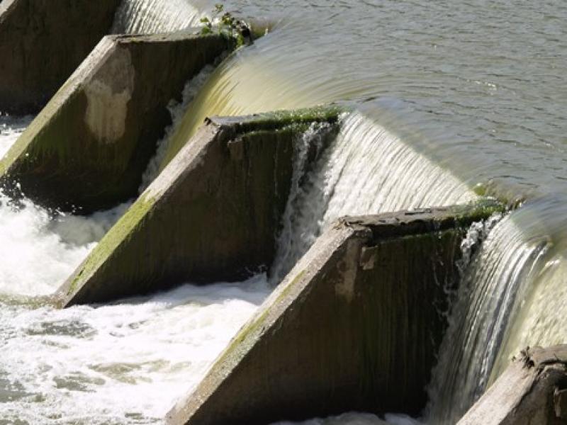 Close-up photograph of water flowing over a concrete dam