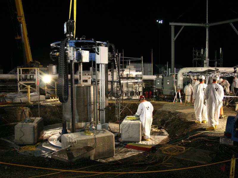 Workers in protective gear use equipment
