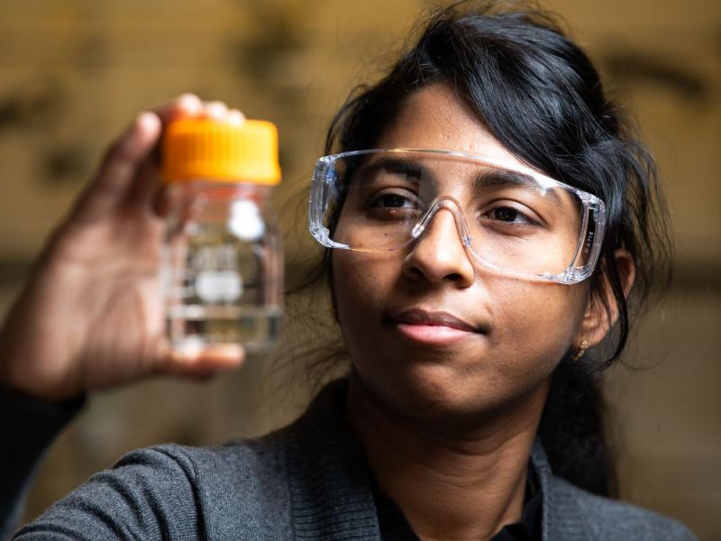 PNNL chemist Jotheeswari Kothandaraman holds EEMPA, a carbon-capturing solvent used in her most recent study.