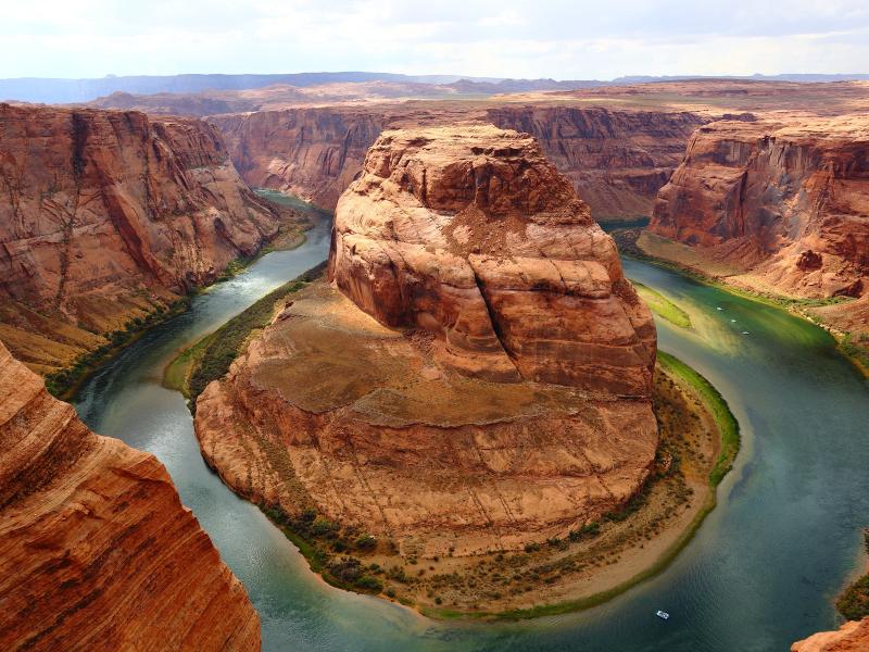 Photograph of a river bend around red rocks through a canyon.