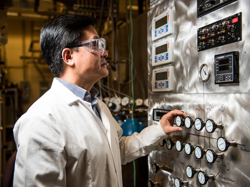 Yong Wang, in lab safety gear, operating machinery