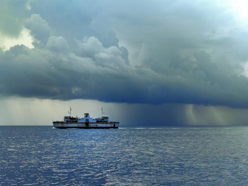 Boat on an ocean underneath dark clouds