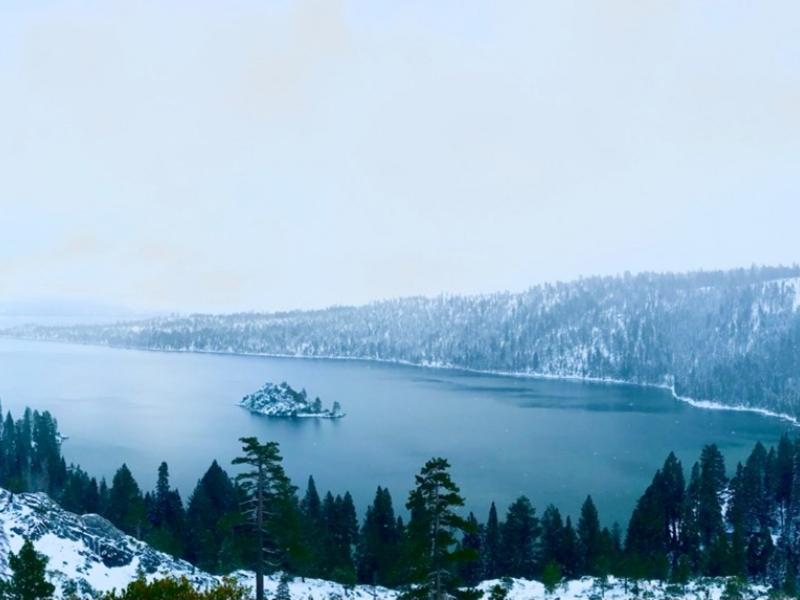 Photograph of a snowy lake, with a cool, washed out color palate.