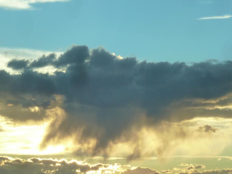 clouds with heavy rain backlit by the sun