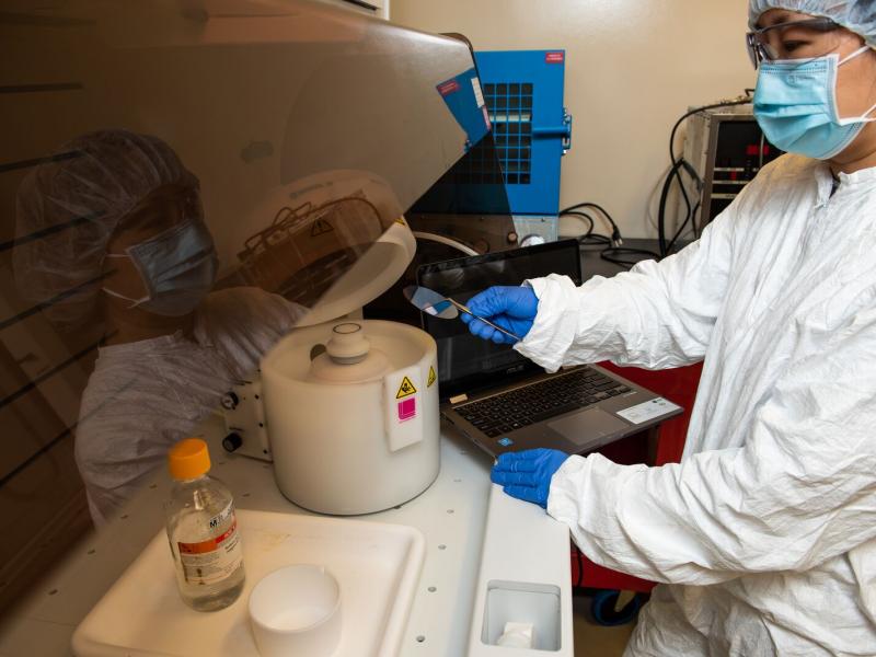 Researcher Amy Qiao is operating a computer-controlled spin coater