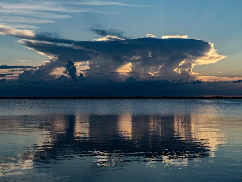 Backlit clouds over body of water