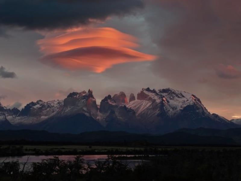 orange puffs of clouds above a mountain