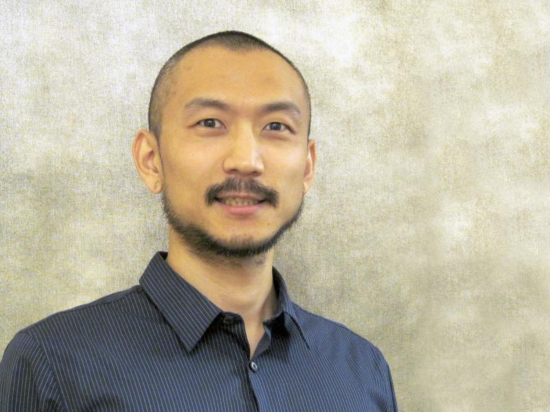 Headshot of smiling man on a tan background