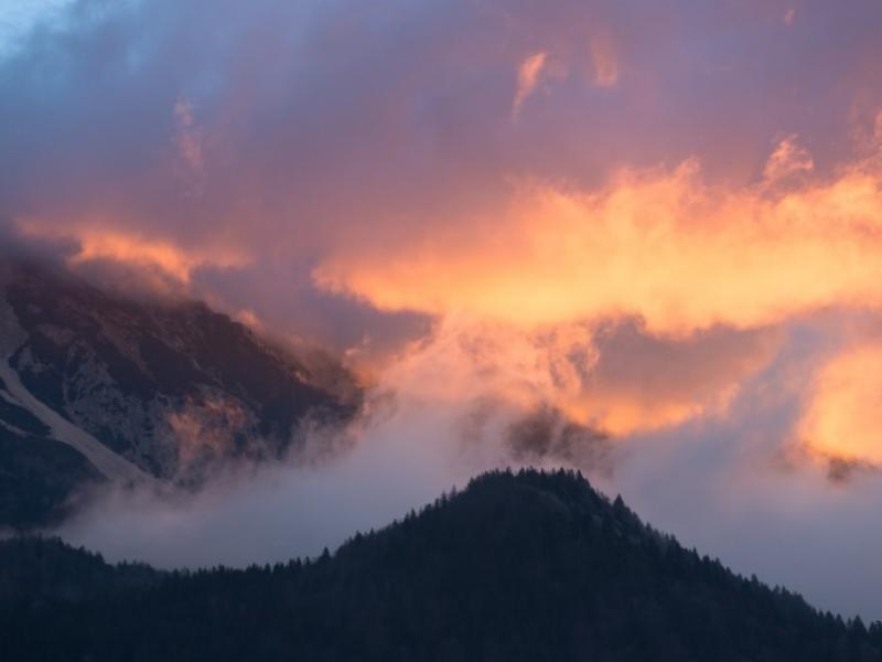 clouds over a hillside at sunset