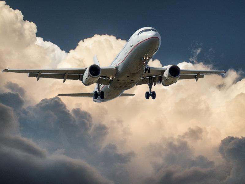 Jet flying with white puffy clouds behind it