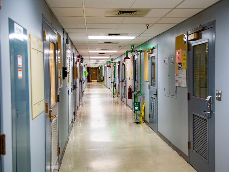 a long empty hallway with many doors, some open and some closed