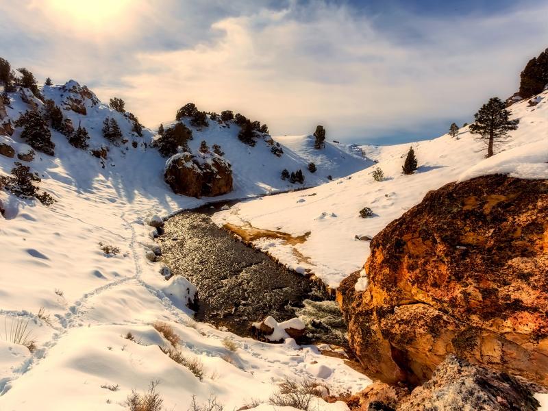 Soft, white snow rests on either side of a California waterway. Winter precipitation includes more than just rain, encompassing snowpack in mountainous areas and other factors that influence climate processes throughout the year. (Photo by © 12019 | Pixabay.com)