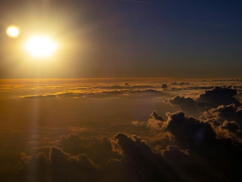 a view of the sunset above the clouds from an airplane