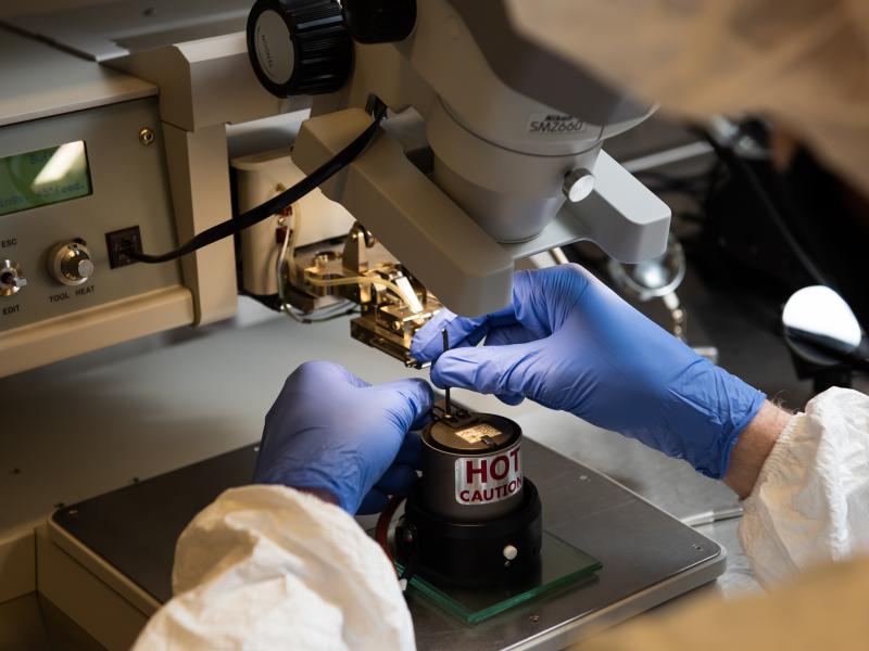 A researcher uses a wire bonder to make interconnections between the micro-circuits on microchips