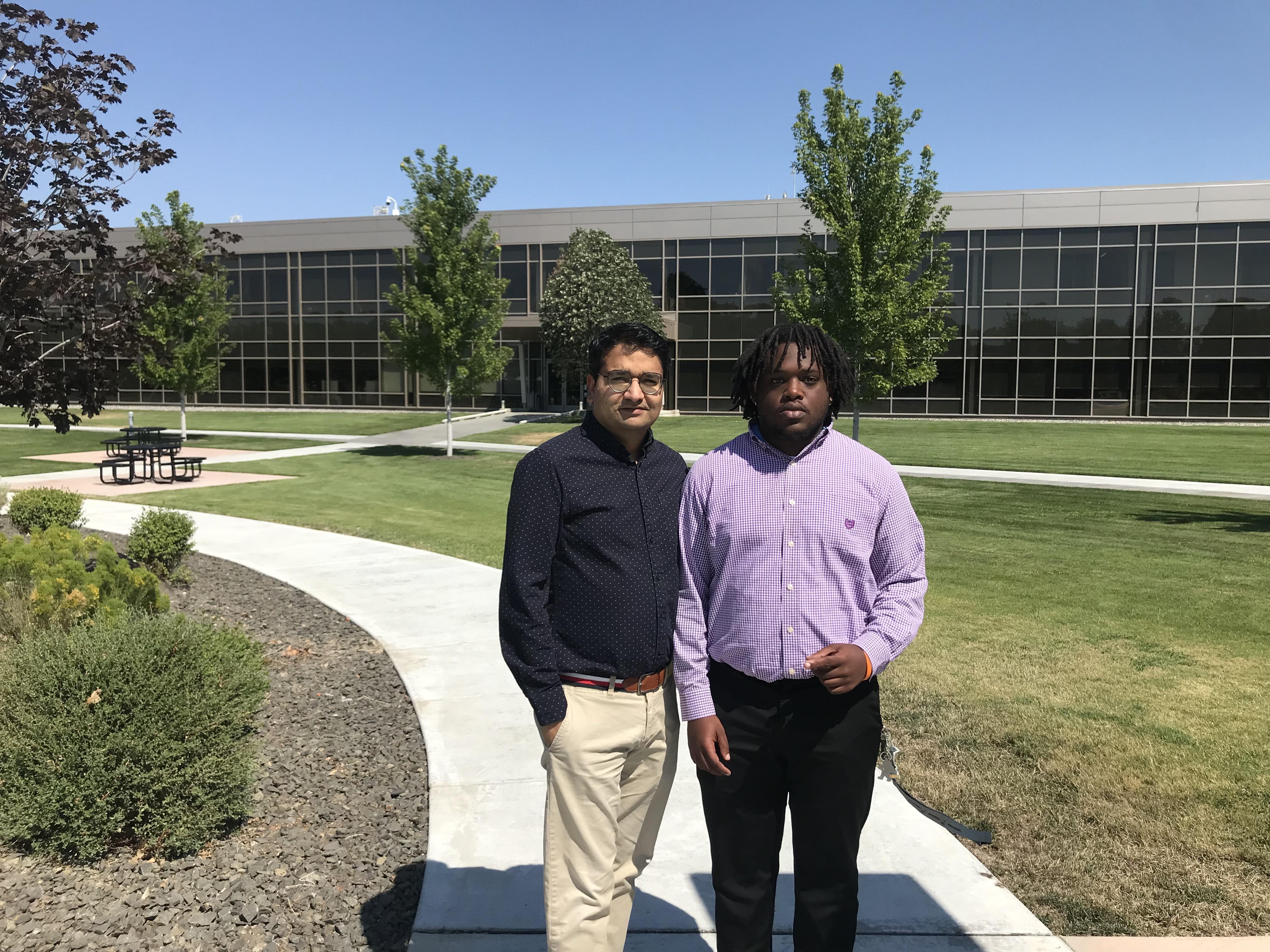 Photo of two researchers in front of a building