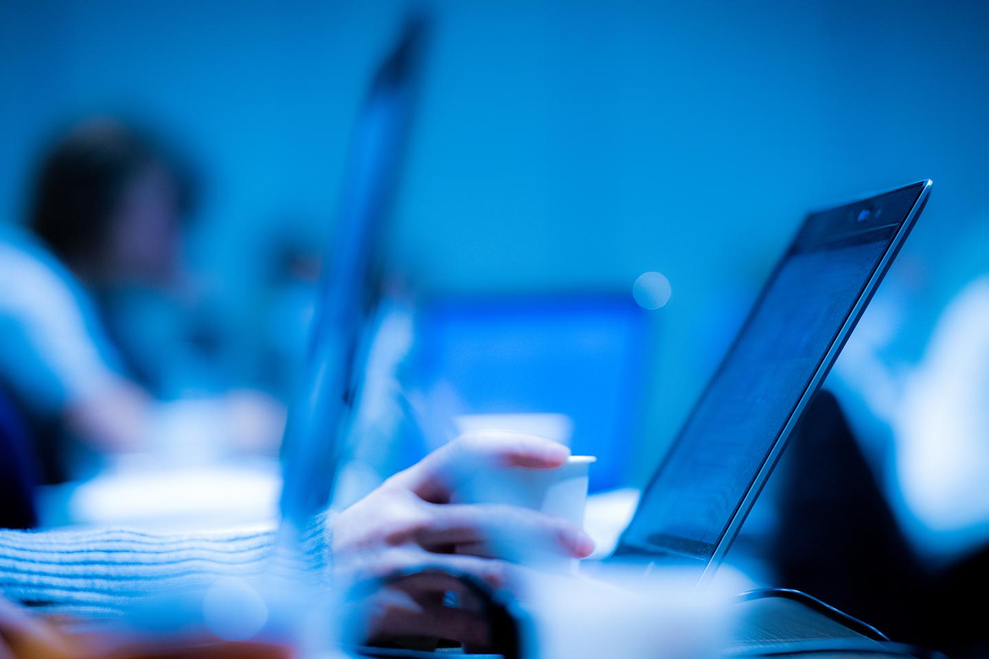 A blurred photo of laptop computers in a line