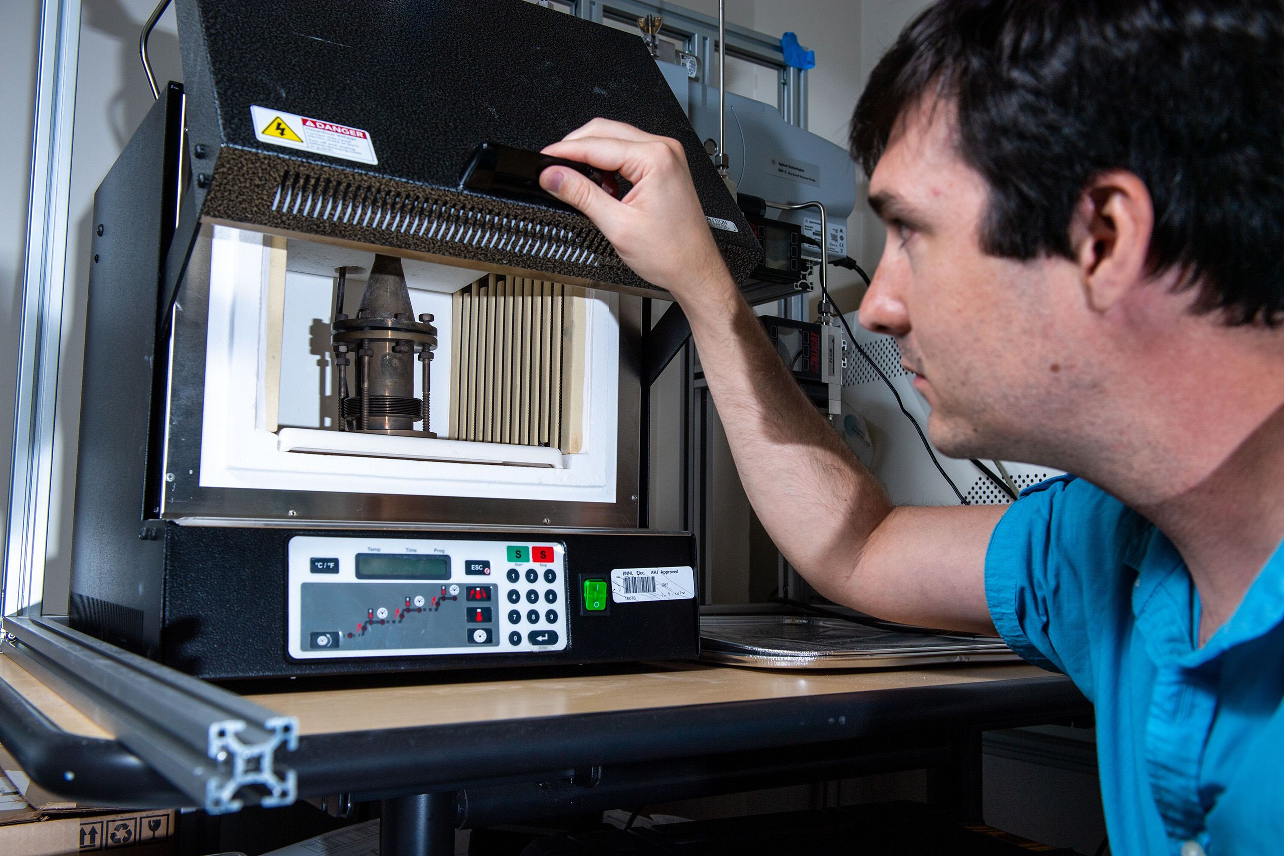 A researcher examines a piece of laboratory equipment