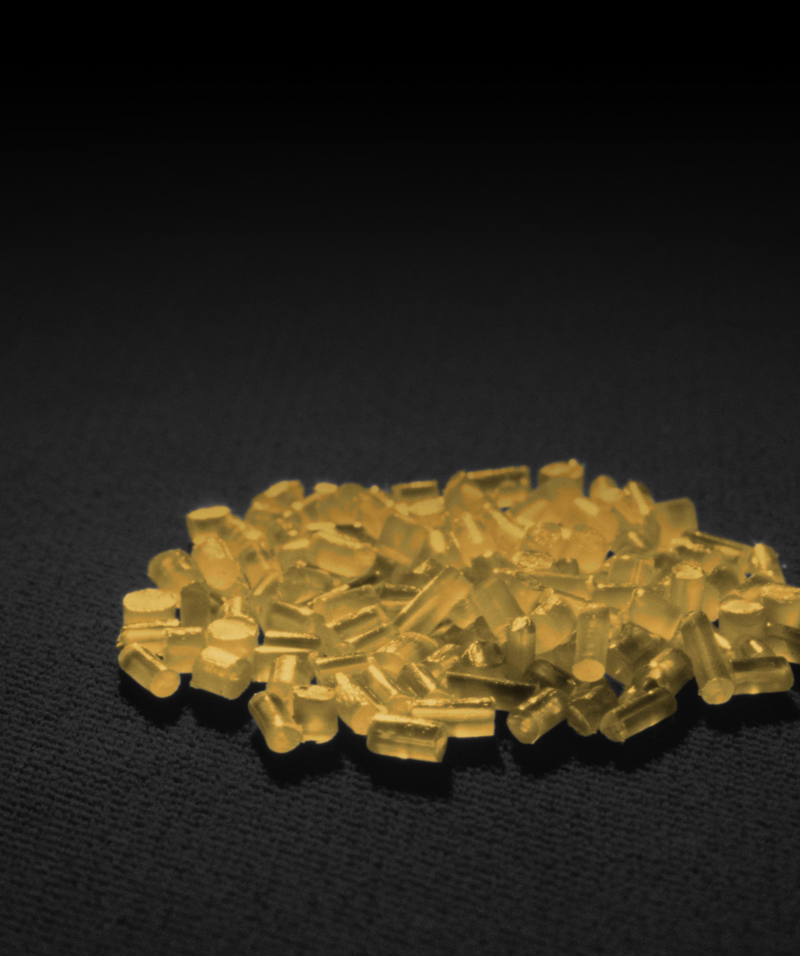 A pile of small, translucent, yellow cylindrical objects