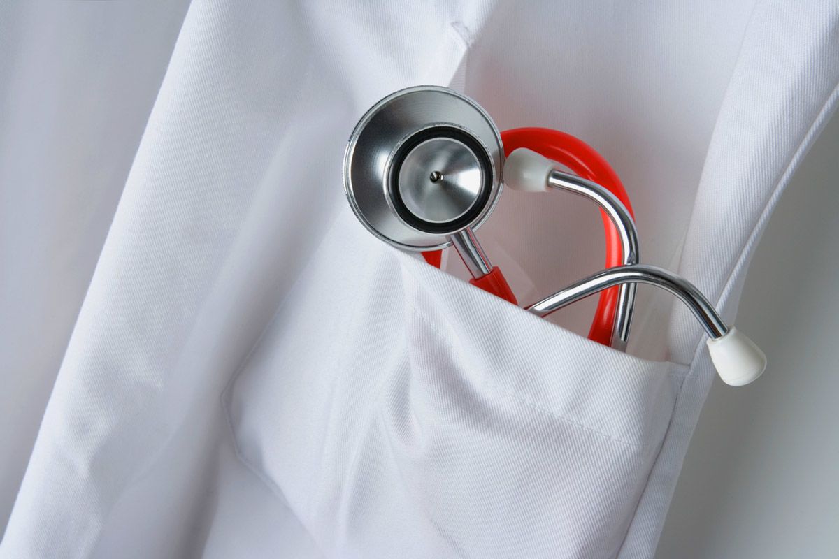 a red and white stethoscope in the pocket of a white medical jacket
