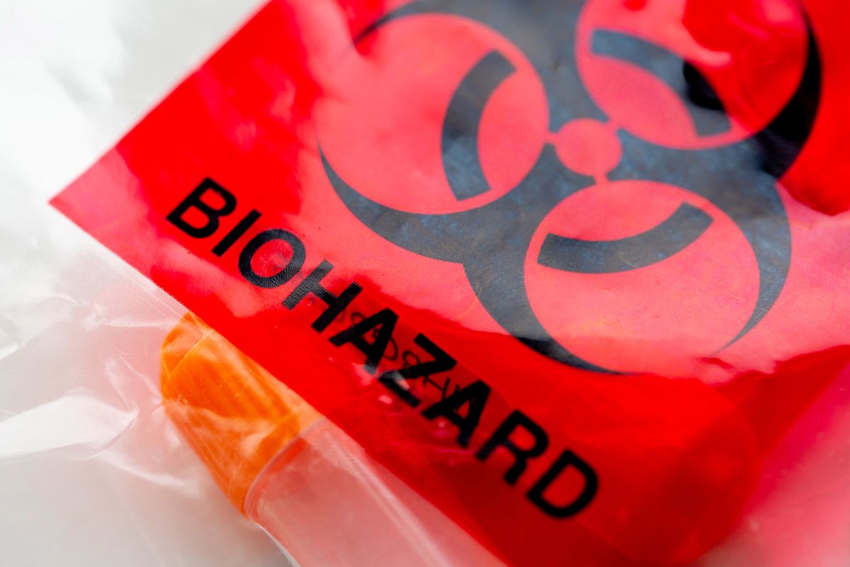 a plastic bag containing sample tubes with a red and black "biohazard" label