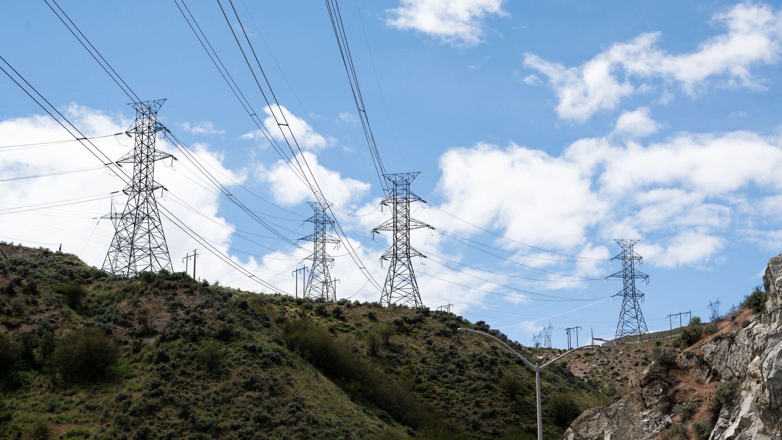 metal power towers and lines running across a rocky ridgeline